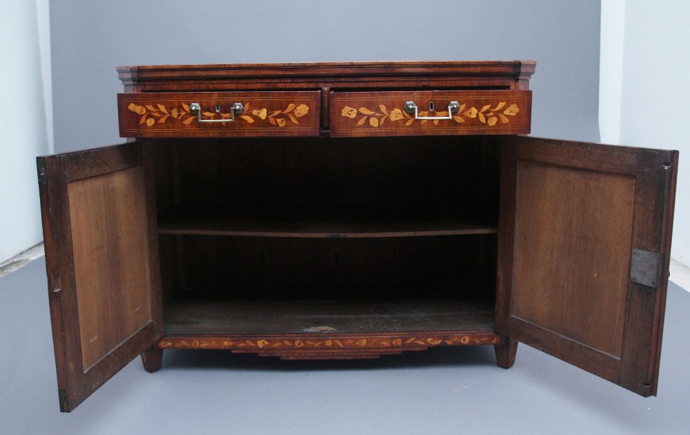 An early 19th-century Dutch mahogany travelling cabinet with intricate floral marquetry inlay, twin drawers over a two-door cupboard, and metal side carrying handles. View V