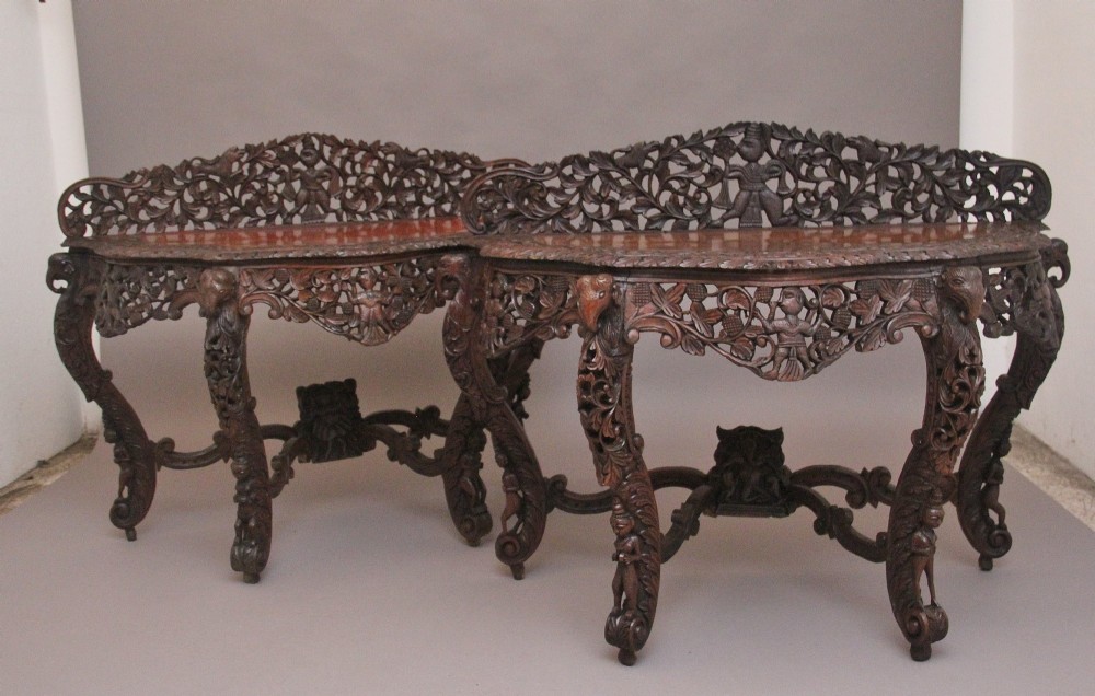 A pair of 19th-century dark wood console tables featuring intricate openwork carving, gallery backs, curved legs, and polished timber tops. View II