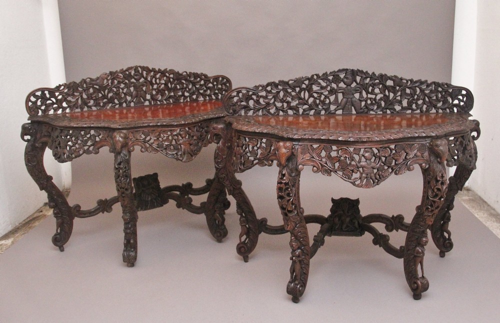 A pair of 19th-century dark wood console tables featuring intricate openwork carving, gallery backs, curved legs, and polished timber tops. View III