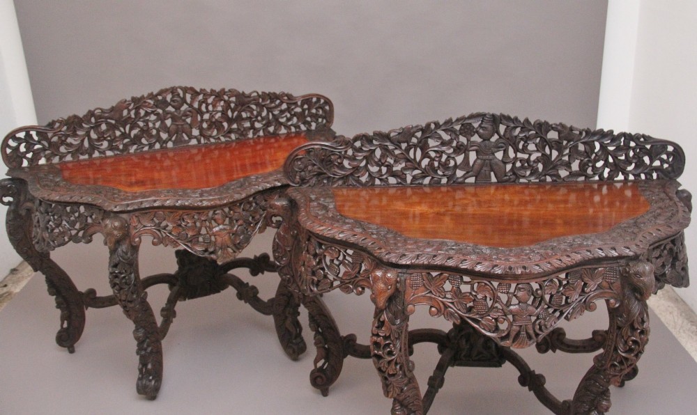 A pair of 19th-century dark wood console tables featuring intricate openwork carving, gallery backs, curved legs, and polished timber tops. View IV