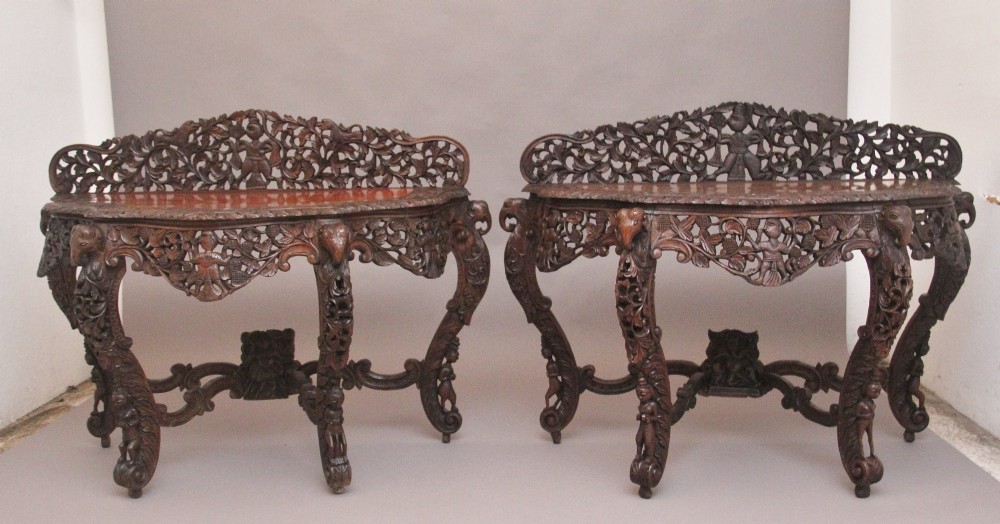 A pair of 19th-century dark wood console tables featuring intricate openwork carving, gallery backs, curved legs, and polished timber tops. View XI