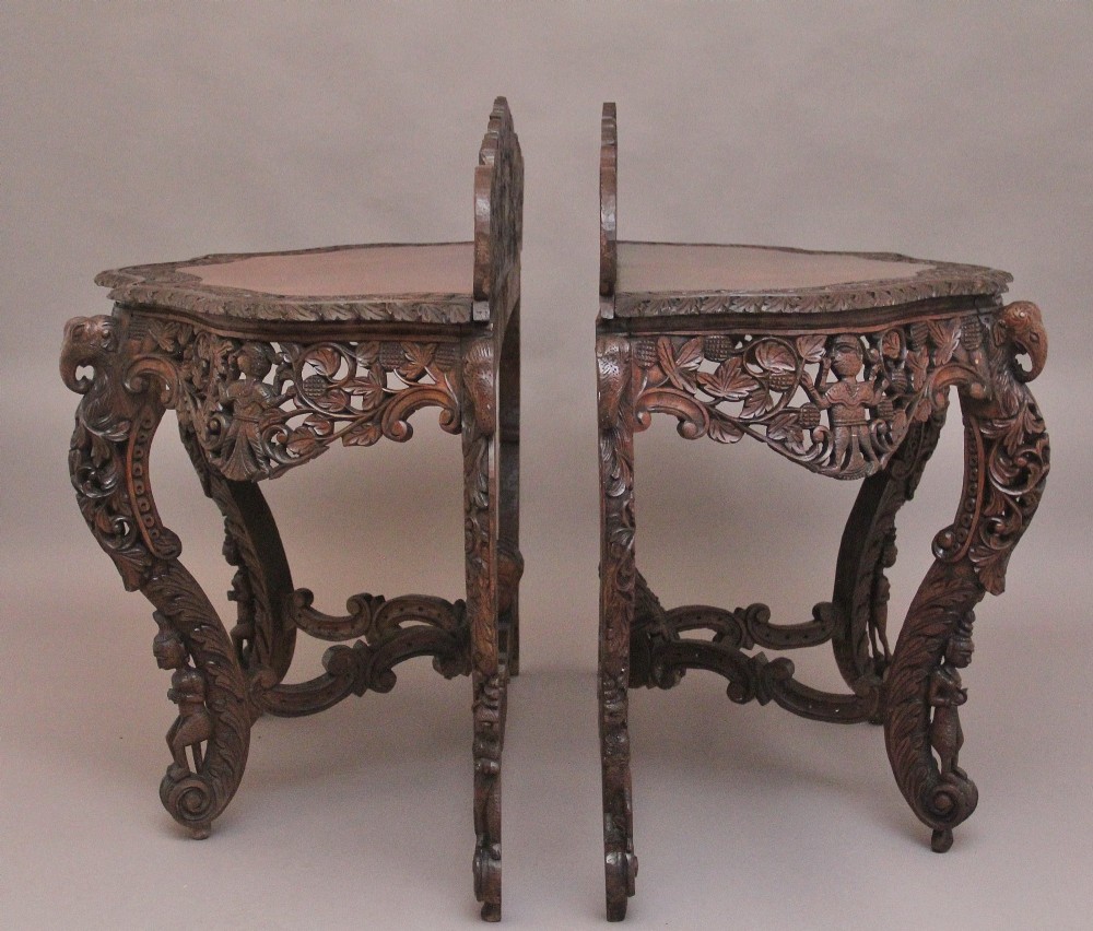 A pair of 19th-century dark wood console tables featuring intricate openwork carving, gallery backs, curved legs, and polished timber tops. View XIV