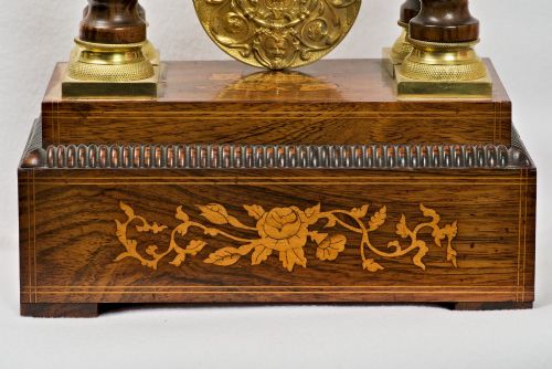 fig 4. A 19th-century rosewood portico clock featuring floral marquetry inlays, twin barley-twist columns with gilt capitals, and a white enamel dial with an ornate gilt bezel.