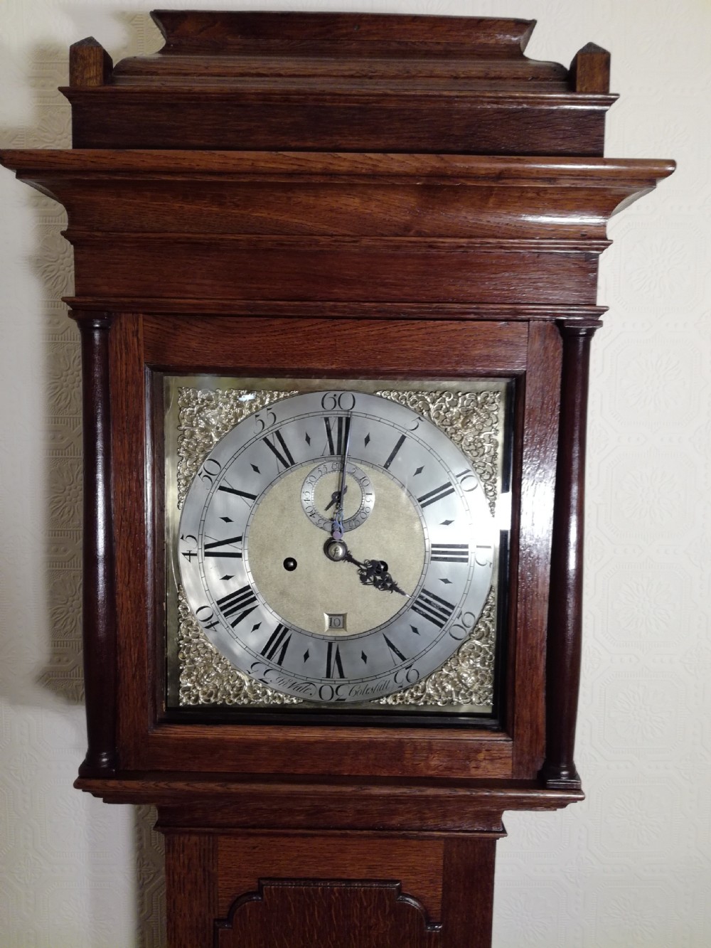 An 18th-century Georgian dark oak longcase clock featuring a square brass dial with decorative corner spandrels and a moulded hood. View II