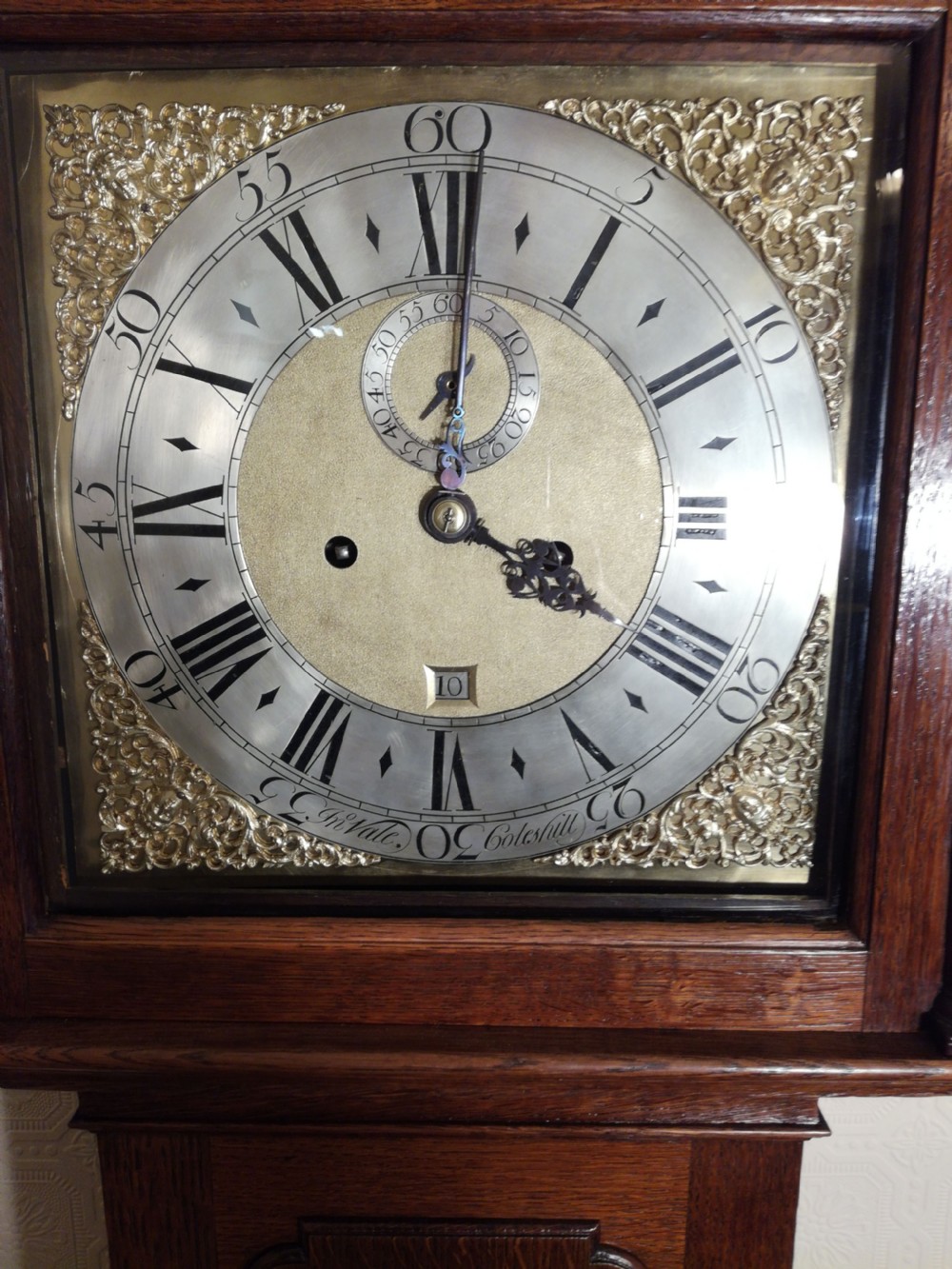An 18th-century Georgian dark oak longcase clock featuring a square brass dial with decorative corner spandrels and a moulded hood. View III