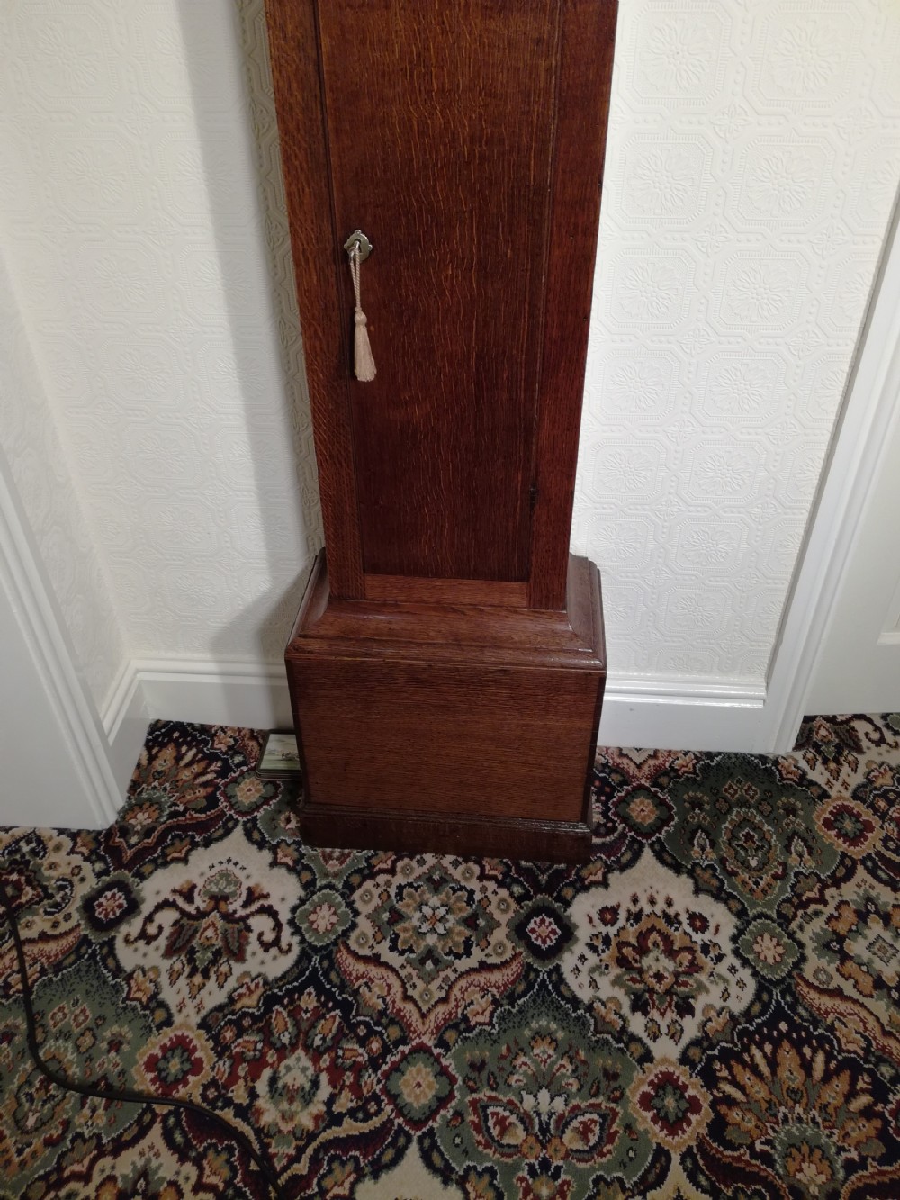 An 18th-century Georgian dark oak longcase clock featuring a square brass dial with decorative corner spandrels and a moulded hood. View V
