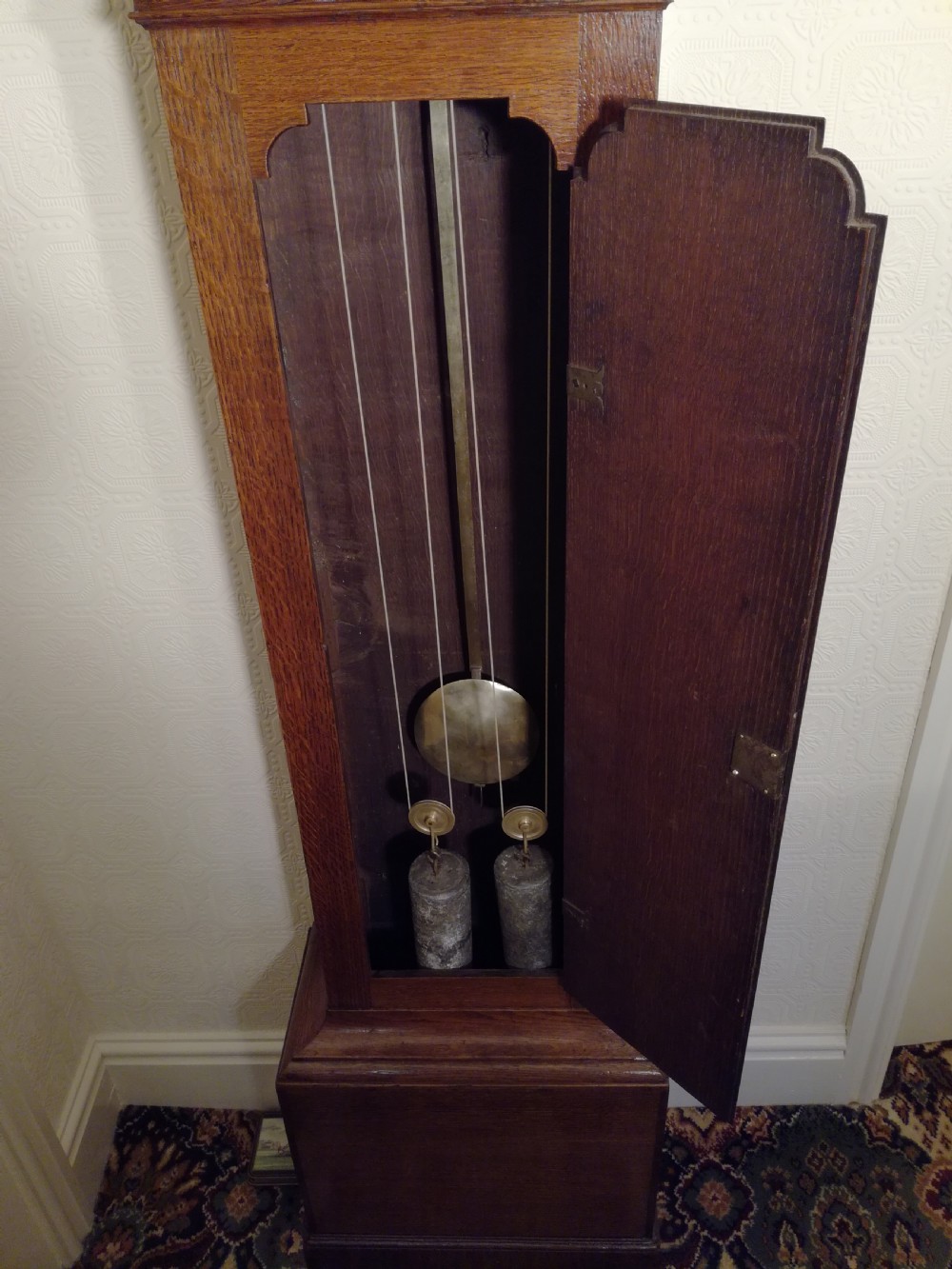 An 18th-century Georgian dark oak longcase clock featuring a square brass dial with decorative corner spandrels and a moulded hood. View VI