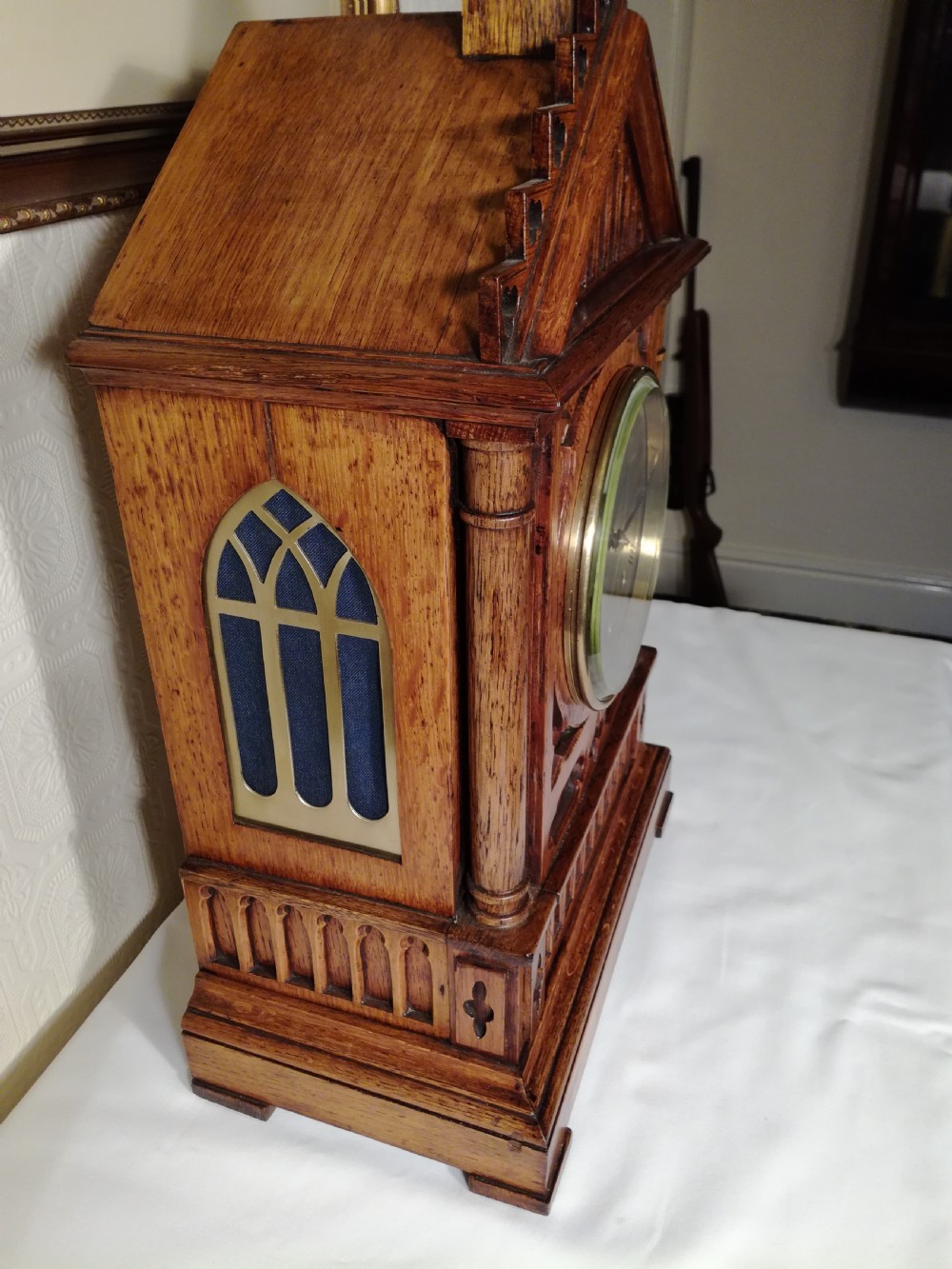A Victorian Gothic Revival carved oak bracket clock featuring a cathedral arch pediment with spire, blind tracery carving, corner columns, and a silvered dial with Roman numerals. View III