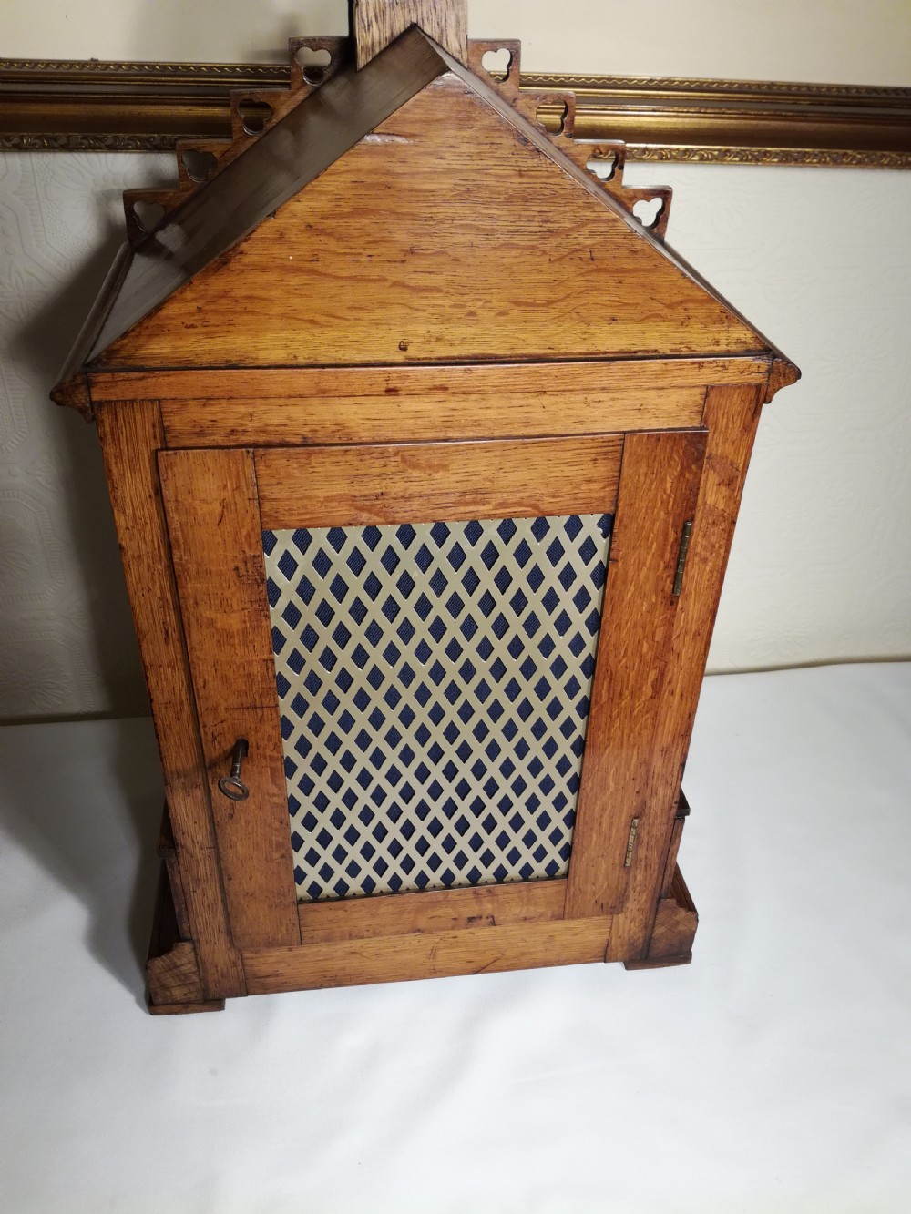A Victorian Gothic Revival carved oak bracket clock featuring a cathedral arch pediment with spire, blind tracery carving, corner columns, and a silvered dial with Roman numerals. View VIII