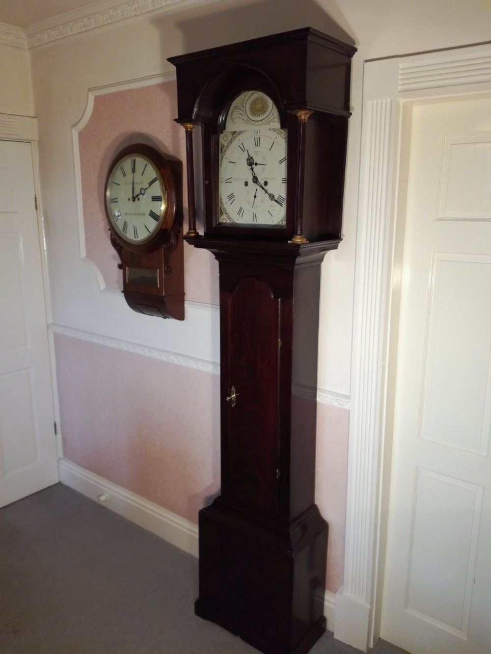 A Georgian dark mahogany longcase clock featuring an arched dial hood with turned columns and a tall waist door. View III