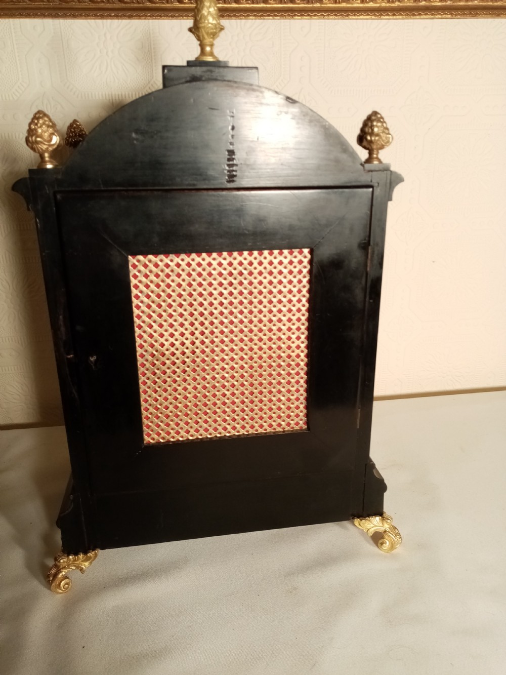 A Victorian ebonised bracket clock featuring gilt brass caryatid mounts, pinecone finials, scroll feet, and a brass dial with silvered chapter ring. View VIII