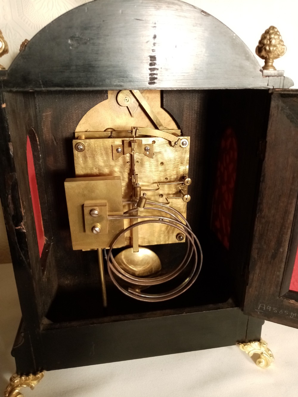 A Victorian ebonised bracket clock featuring gilt brass caryatid mounts, pinecone finials, scroll feet, and a brass dial with silvered chapter ring. View IX