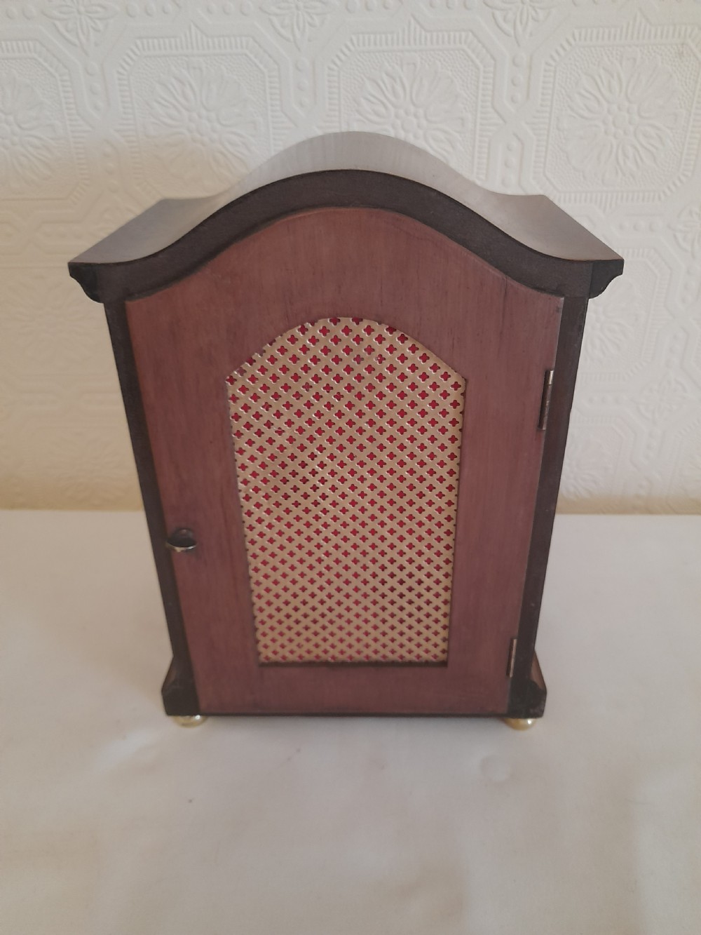 An arched mahogany wooden bracket clock with a silvered brass dial displaying Roman numerals and a small regulating dial at the top. View VI