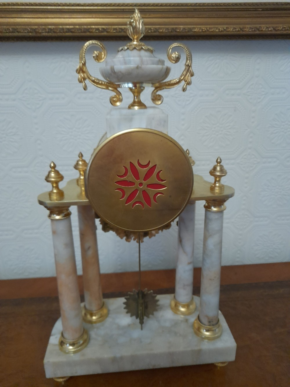 A French Louis XVI style marble and gilt brass portico mantel clock featuring four columns, floral swags, an urn finial, and an enamel dial. View V