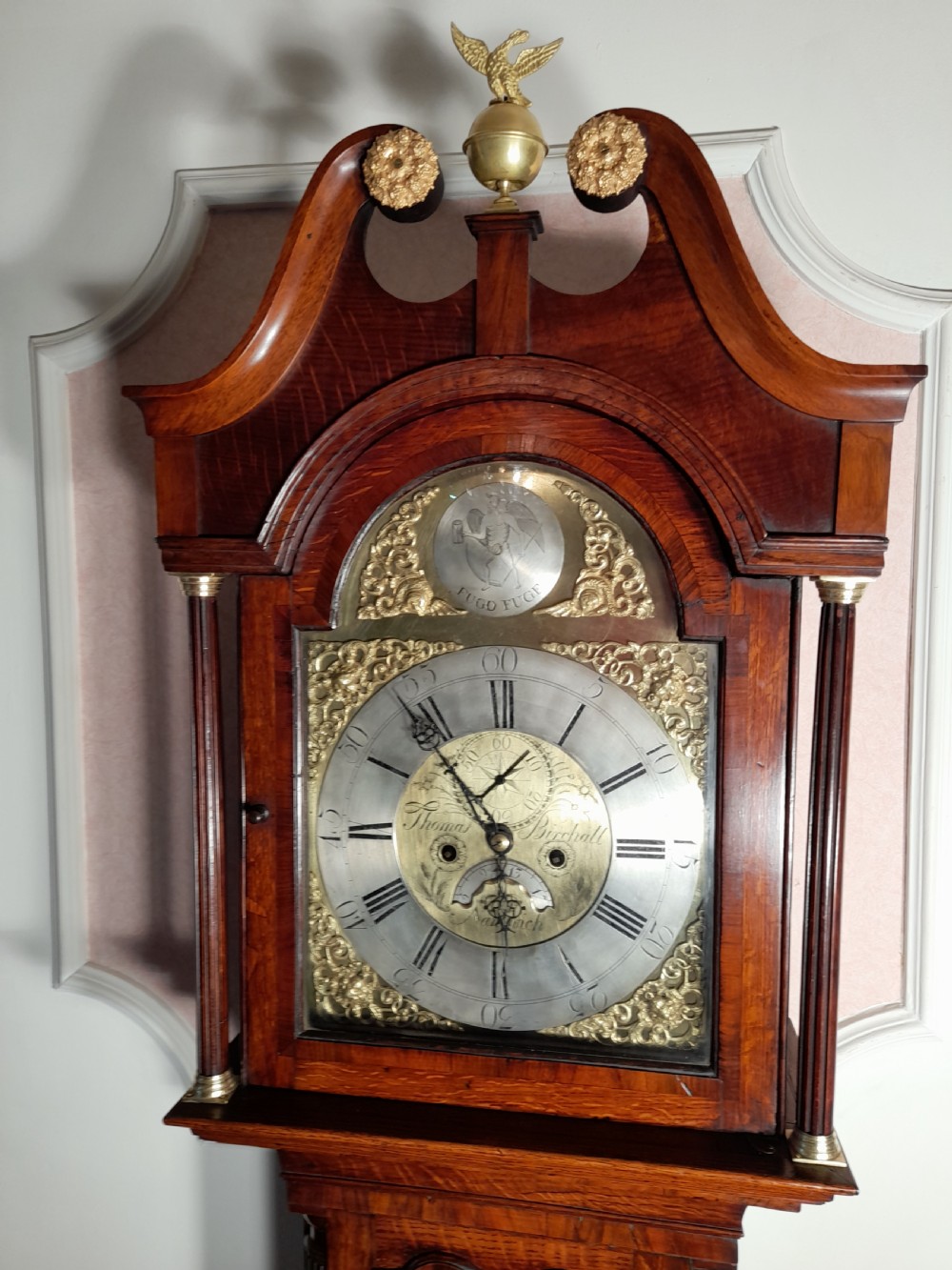 A Georgian mahogany longcase clock featuring a swan-neck pediment with a brass eagle finial and an engraved brass dial. View II