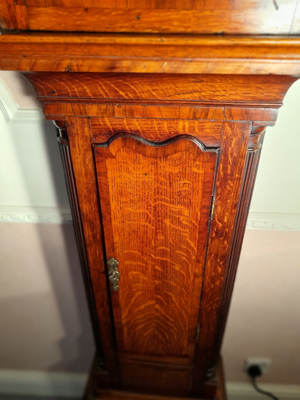 A Georgian mahogany longcase clock featuring a swan-neck pediment with a brass eagle finial and an engraved brass dial. View VI