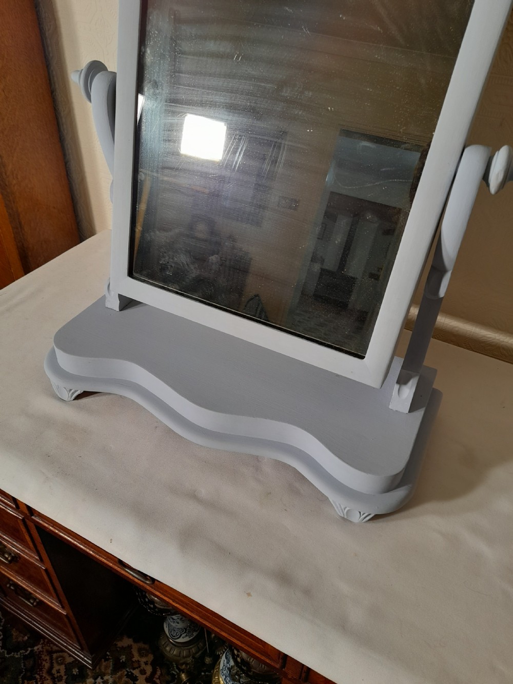 A grey-painted Victorian swing dressing table mirror featuring an arched glass frame set between turned supports on a contoured serpentine base. View III