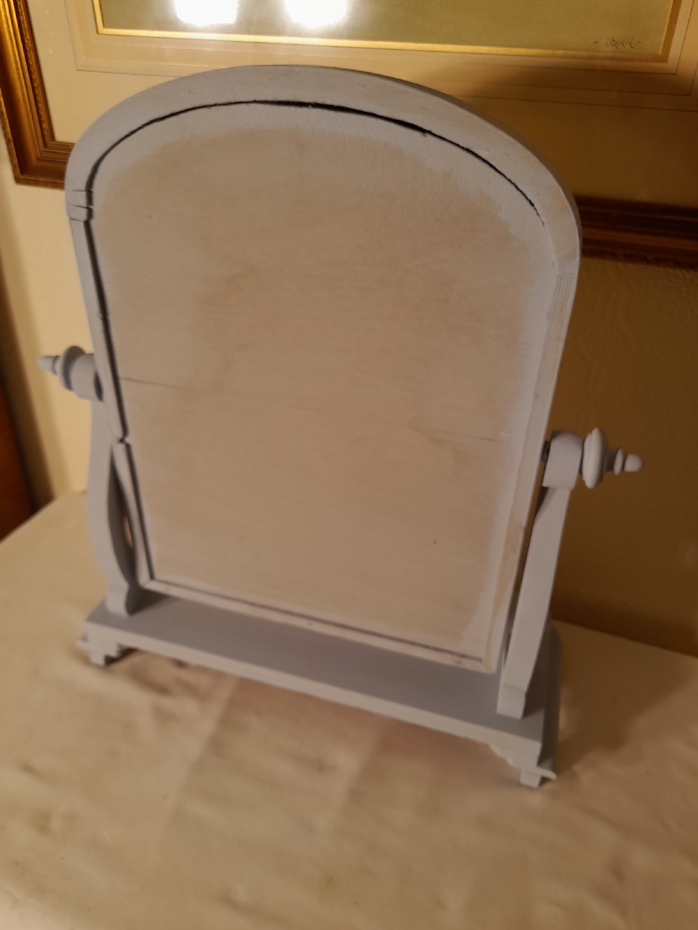 A grey-painted Victorian swing dressing table mirror featuring an arched glass frame set between turned supports on a contoured serpentine base. View IV
