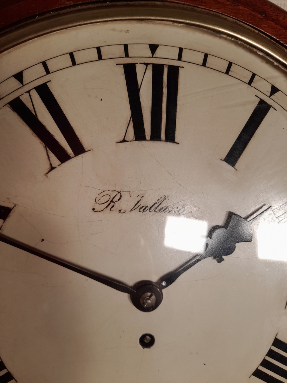 A Victorian rosewood drop-dial wall clock with Roman numerals on a white face, brass accents, and a lower glazed pendulum window. View V