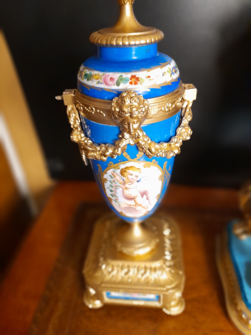 A French gilt bronze clock garniture featuring a central mantel clock with hand-painted blue porcelain panels flanked by two matching ornamental urns. View XI