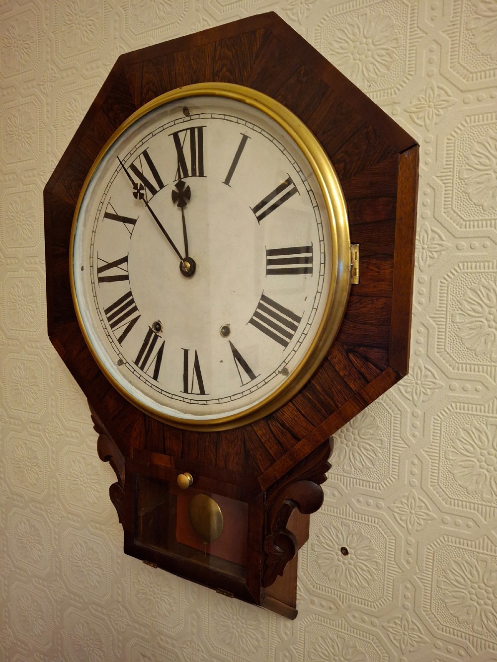 Victorian octagonal drop-dial wall clock crafted from dark rosewood with a brass-bezel white dial and Roman numerals.