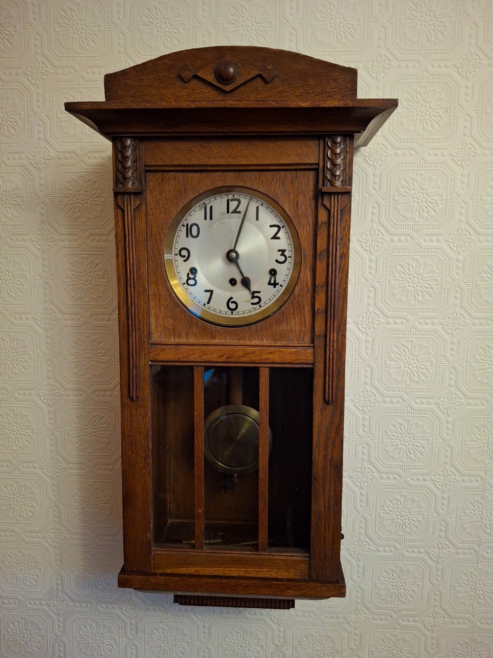 An Art Nouveau mahogany mantel clock featuring a balloon-shaped case with inlaid urn marquetry, boxwood stringing, a circular white dial with Roman numerals, and a brass bezel. View V
