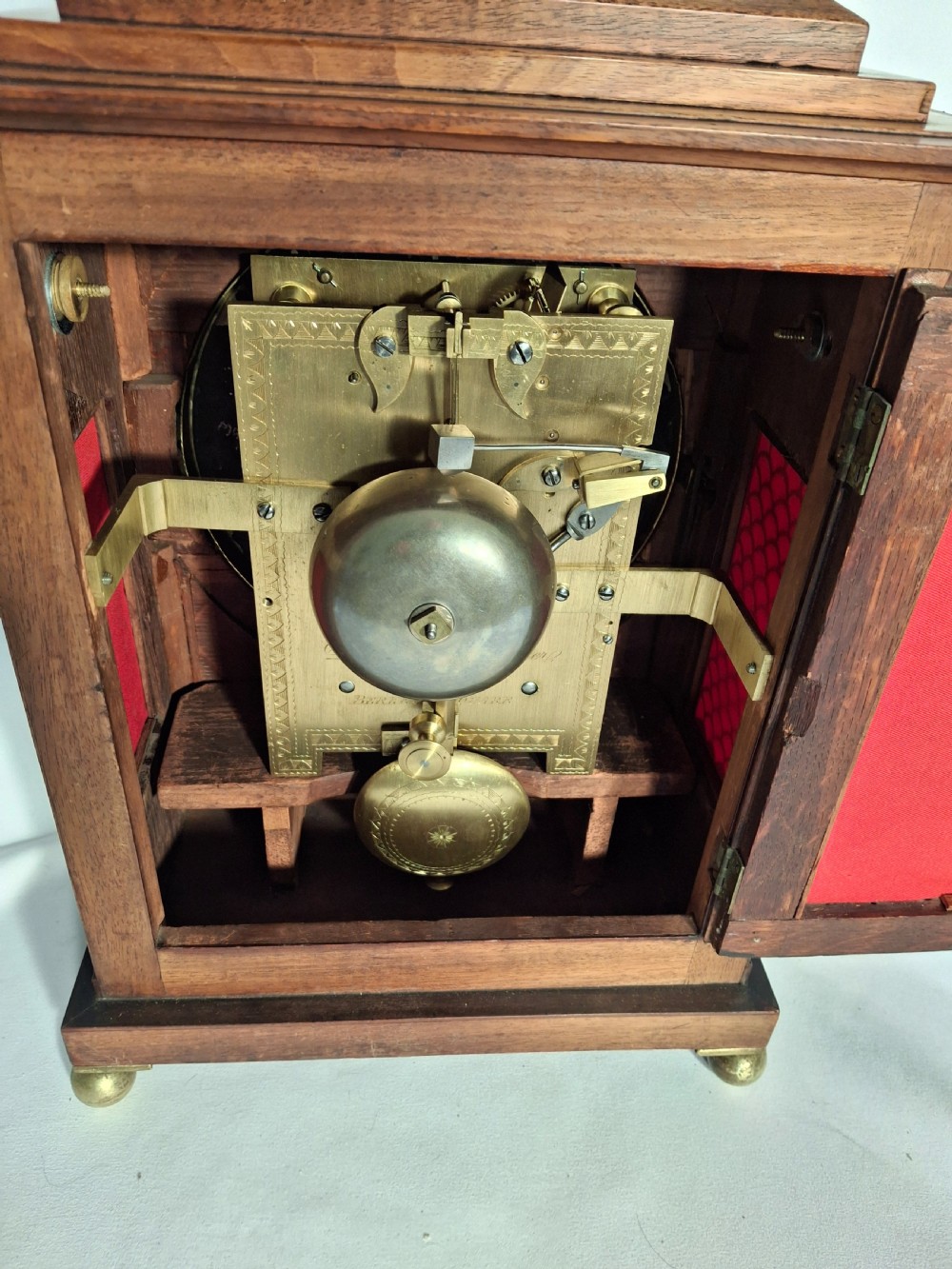 A George III mahogany bracket clock featuring a brass pineapple finial, brass corner spandrels, ball feet, and a white dial with Roman numerals. View V