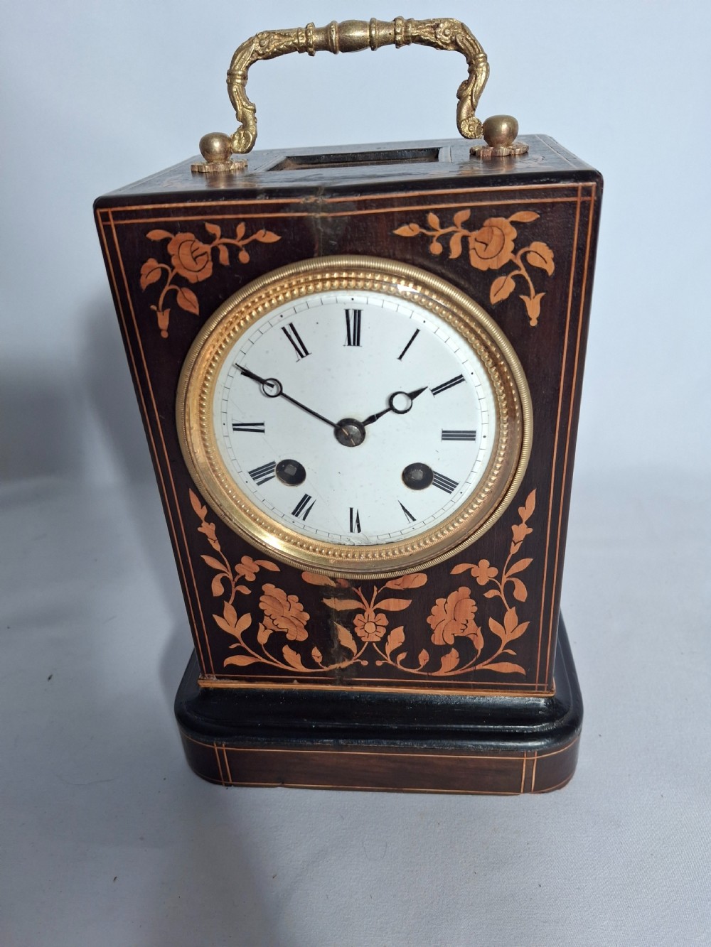 A George III mahogany bracket clock featuring a brass pineapple finial, brass corner spandrels, ball feet, and a white dial with Roman numerals. View VII