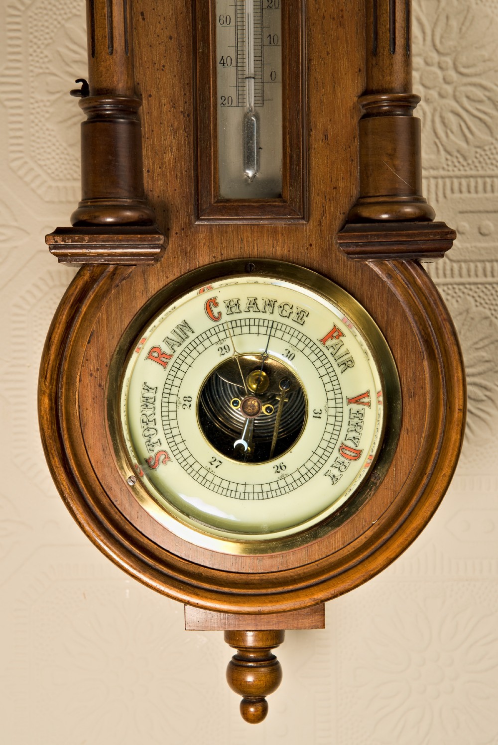 A wall-hung antique walnut clock, thermometer, and aneroid barometer companion set featuring carved pediment ornamentation and brass-rimmed dials. View VII