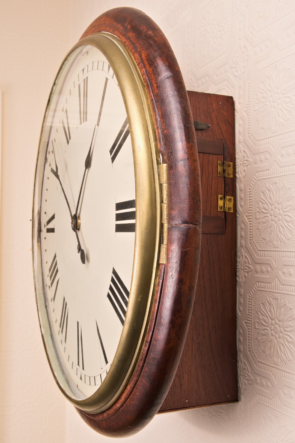 A large circular antique wall clock featuring a dark mahogany surround, turned brass bezel, and a cream dial with black Roman numerals. View VIII