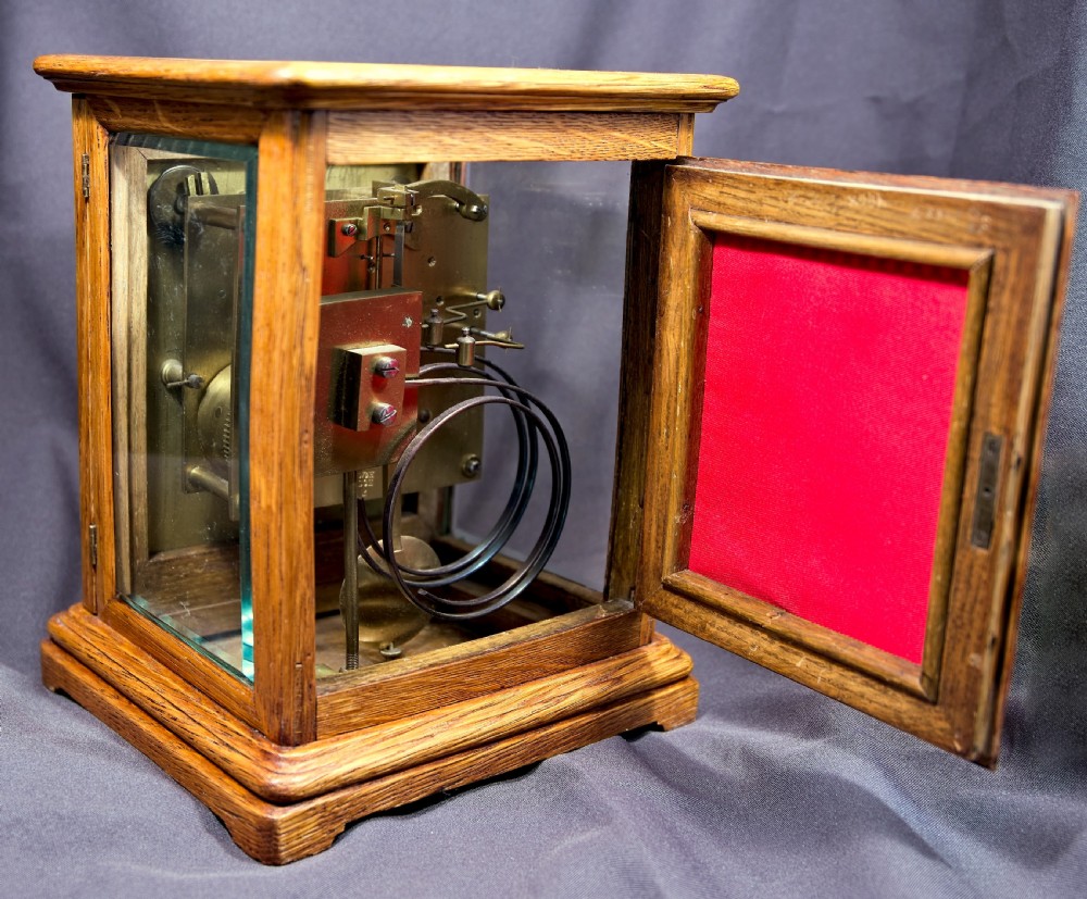 An antique golden oak four-glass bracket clock featuring a silvered brass dial with subsidiary chime controls. View III