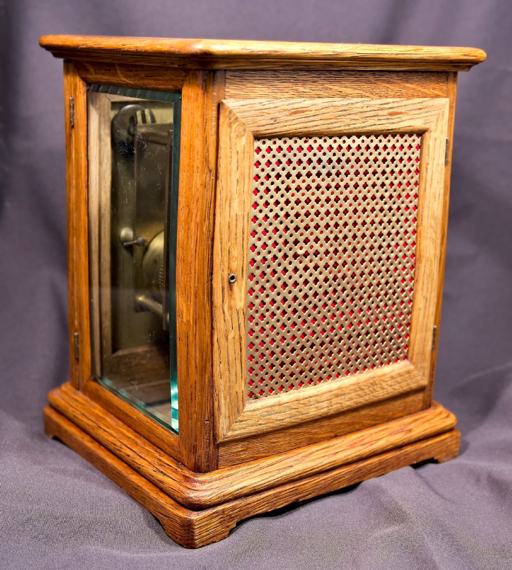 An antique golden oak four-glass bracket clock featuring a silvered brass dial with subsidiary chime controls. View IV