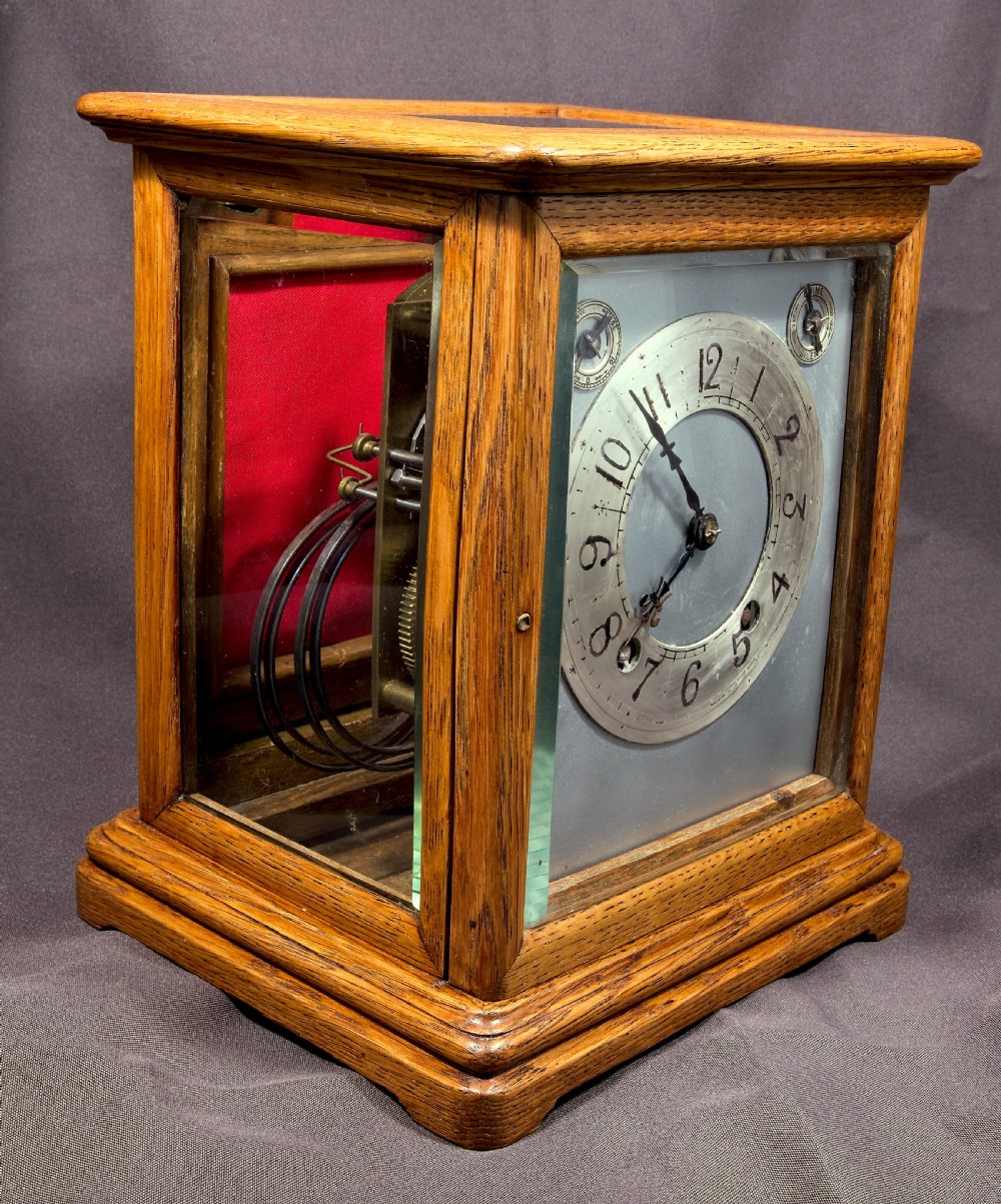 An antique golden oak four-glass bracket clock featuring a silvered brass dial with subsidiary chime controls. View VI