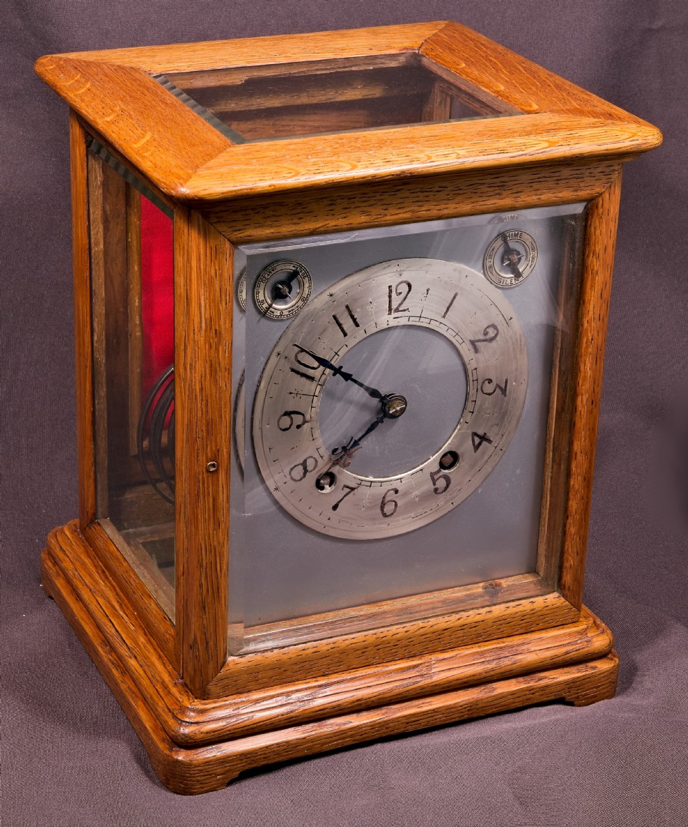 An antique golden oak four-glass bracket clock featuring a silvered brass dial with subsidiary chime controls. View IX