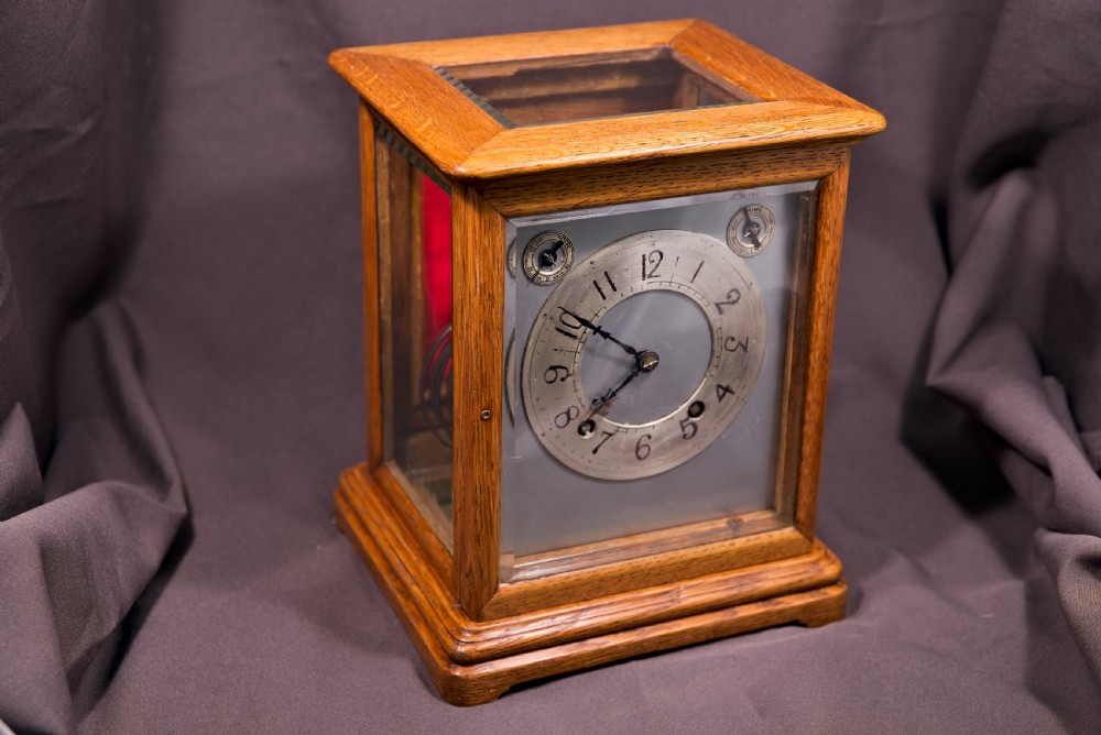 An antique golden oak four-glass bracket clock featuring a silvered brass dial with subsidiary chime controls. View X