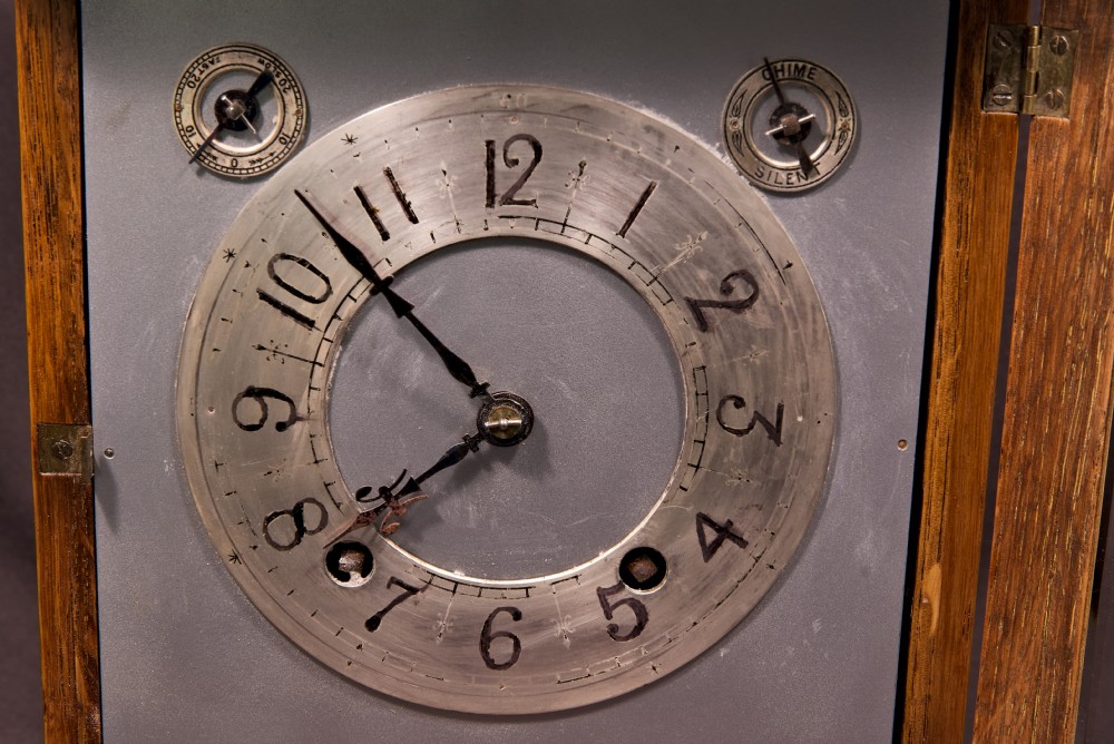 An antique golden oak four-glass bracket clock featuring a silvered brass dial with subsidiary chime controls. View XII