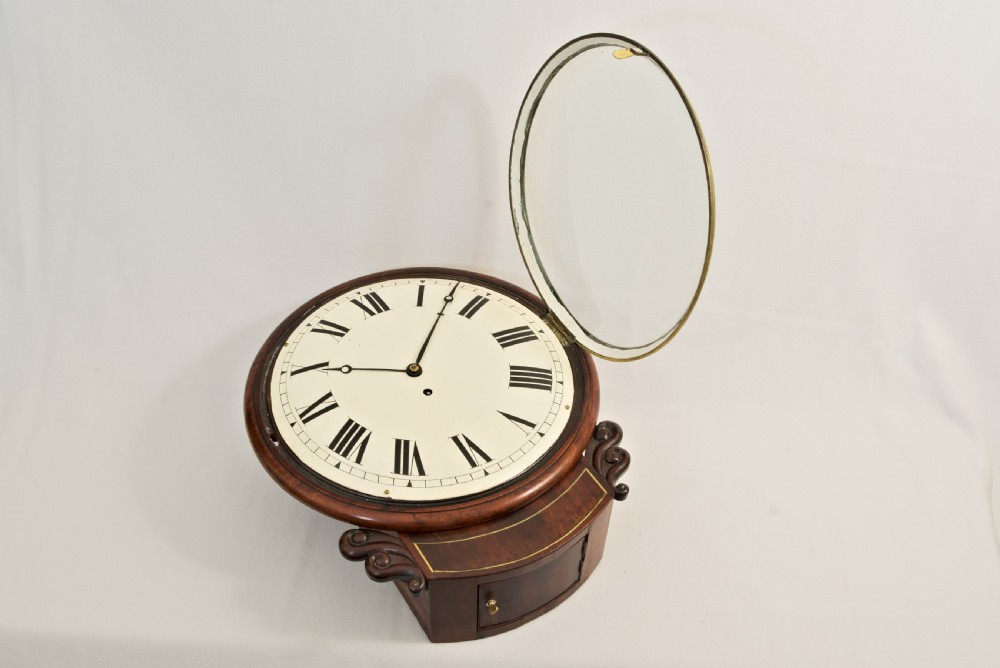 A Victorian mahogany fusee wall clock featuring a cream painted dial with Roman numerals, a brass bezel, and carved side scroll ears. View VII