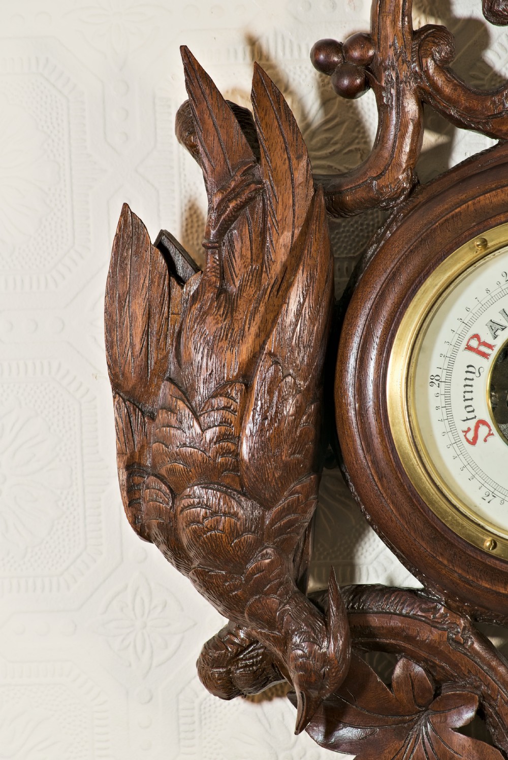 A late 19th-century Black Forest carved wooden wall barometer featuring a chamois head at the top, flanked by carved game animals and foliage around a central dial and upper thermometer tube. View IV