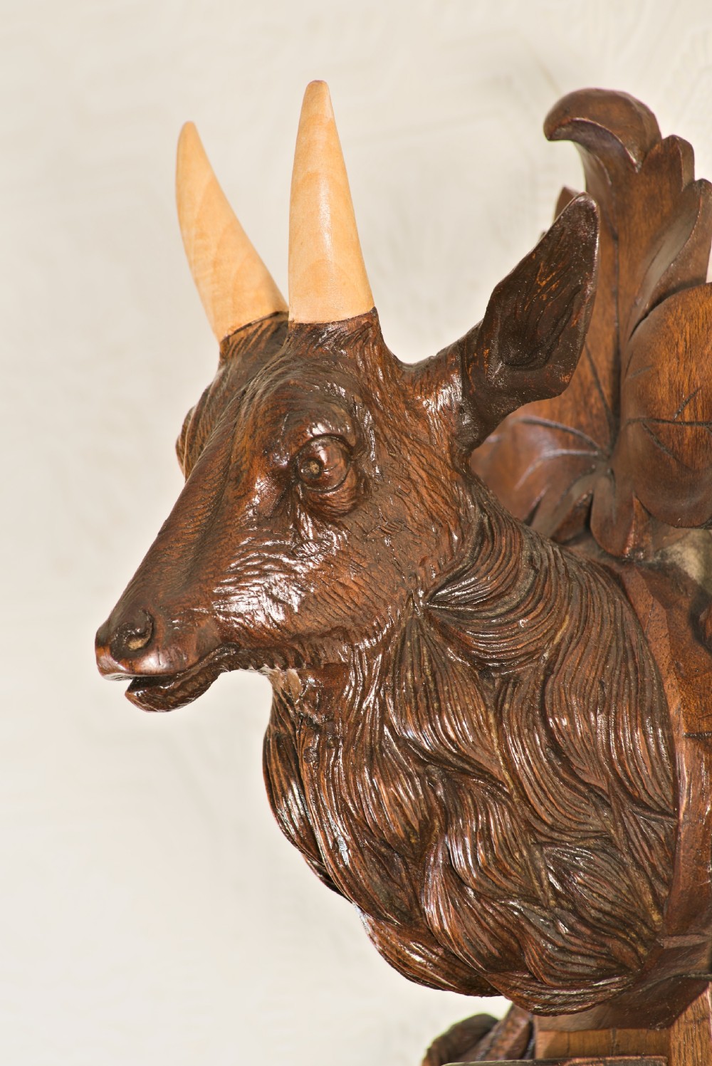 A late 19th-century Black Forest carved wooden wall barometer featuring a chamois head at the top, flanked by carved game animals and foliage around a central dial and upper thermometer tube. View IX