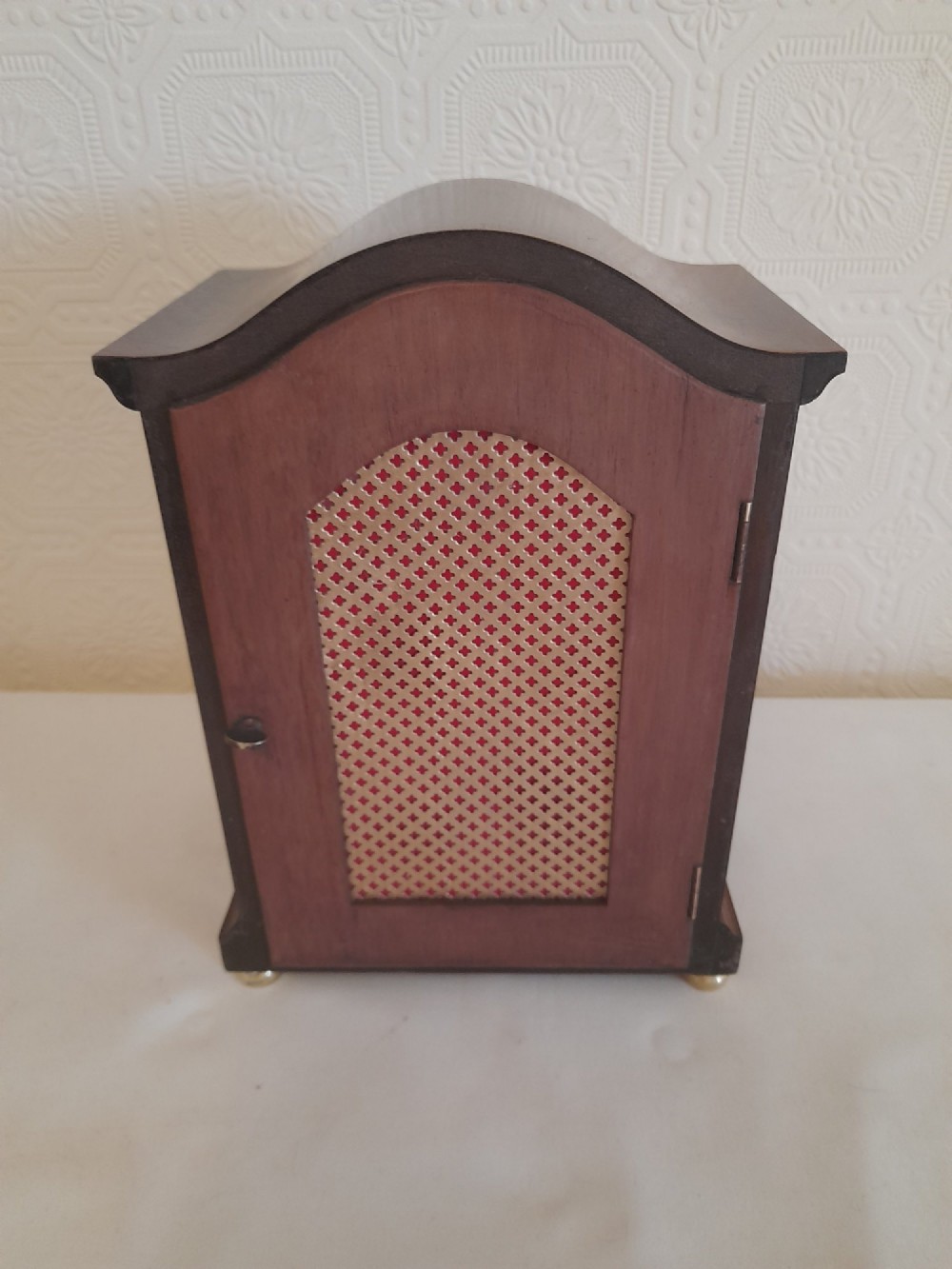 A mahogany bracket clock featuring a swept top profile, brass-framed glass door, and a silvered arched dial with Roman numerals. View V