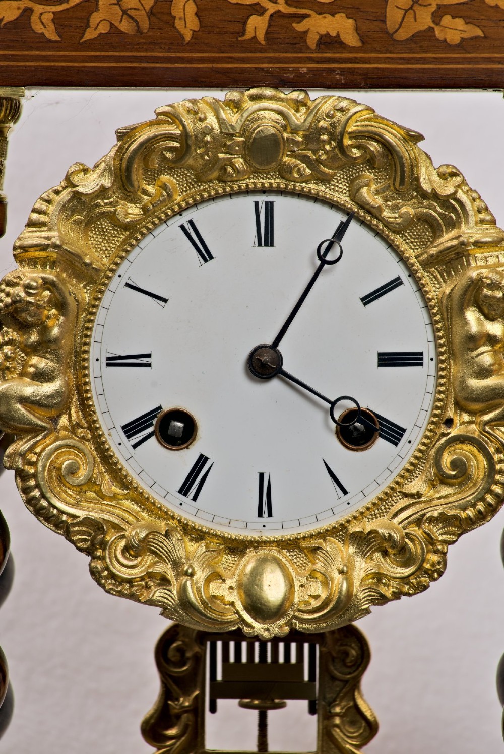 A 19th-century rosewood portico clock featuring floral marquetry inlays, twin barley-twist columns with gilt capitals, and a white enamel dial with an ornate gilt bezel. View III
