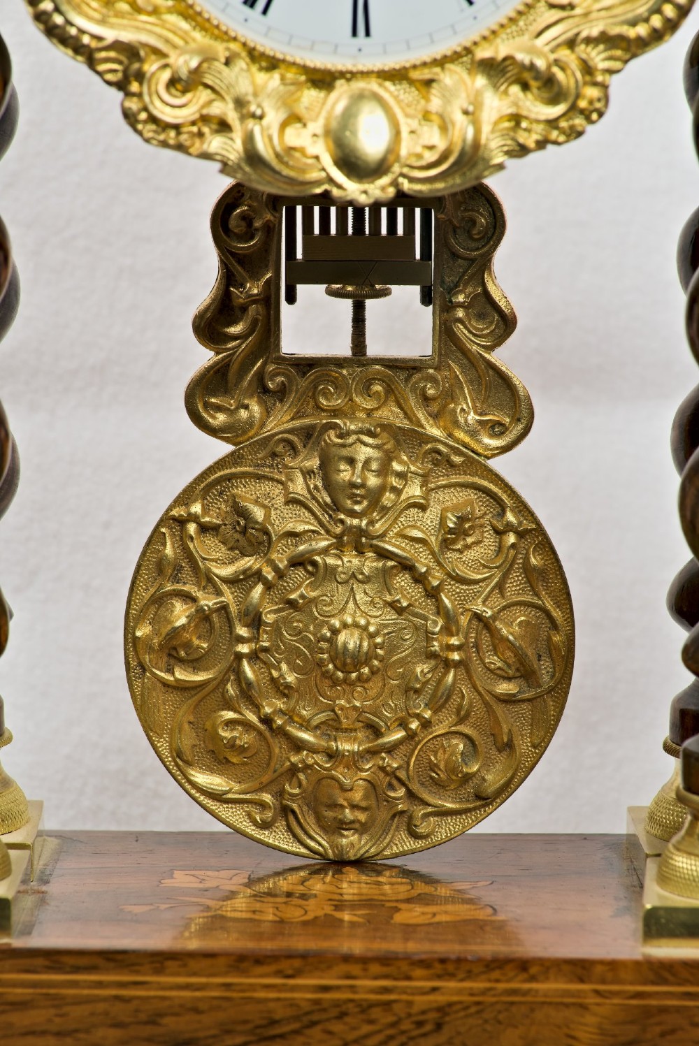 A 19th-century rosewood portico clock featuring floral marquetry inlays, twin barley-twist columns with gilt capitals, and a white enamel dial with an ornate gilt bezel. View IV
