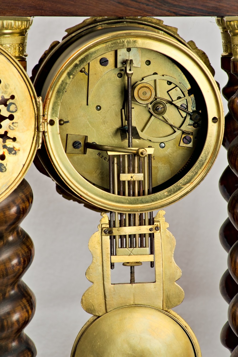 A 19th-century rosewood portico clock featuring floral marquetry inlays, twin barley-twist columns with gilt capitals, and a white enamel dial with an ornate gilt bezel. View VIII