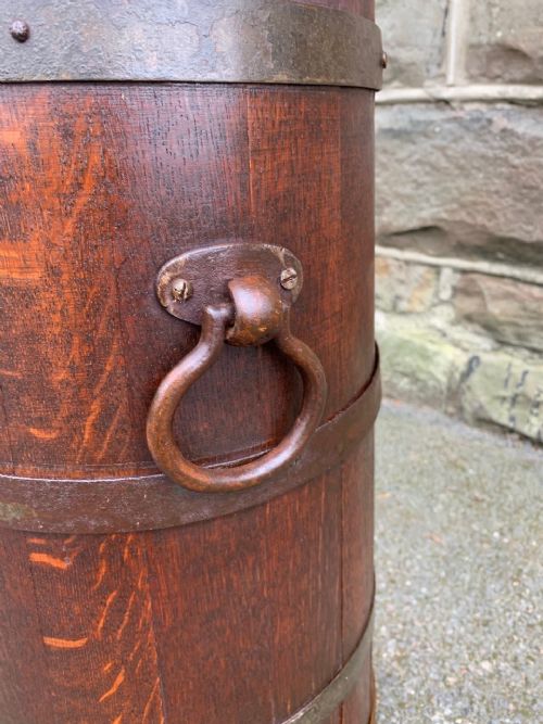 fig 1. A cylindrical coopered oak stick stand bound with horizontal metal hoops and side ring handles.