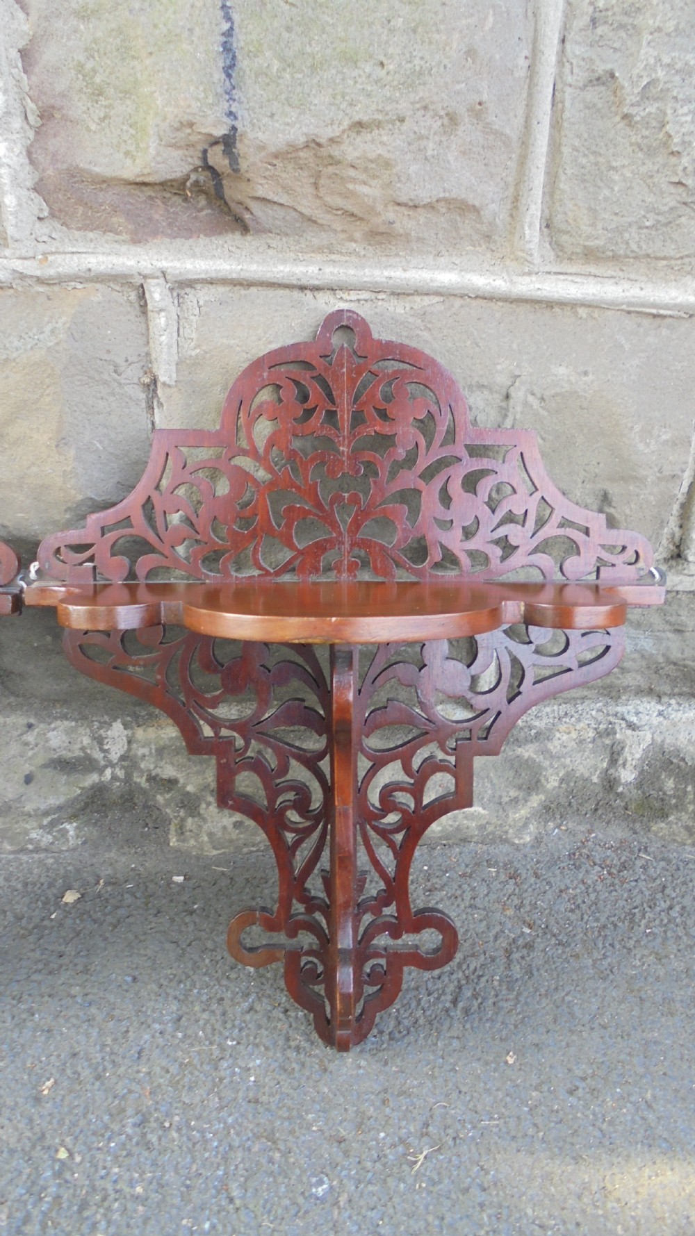 A pair of carved walnut wall brackets featuring pierced fretwork scroll designs and flat top display surfaces. View VII