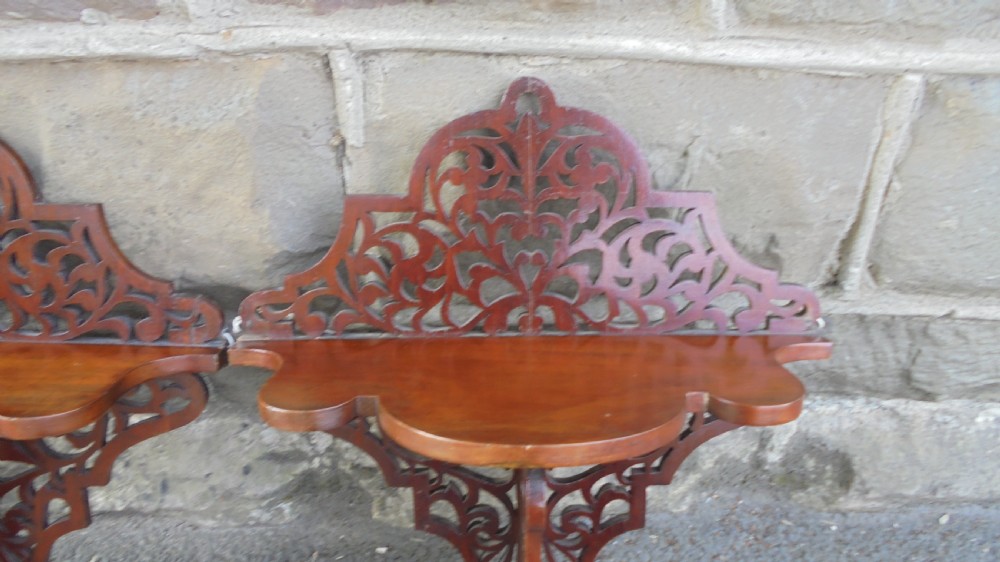 A pair of carved walnut wall brackets featuring pierced fretwork scroll designs and flat top display surfaces. View VIII
