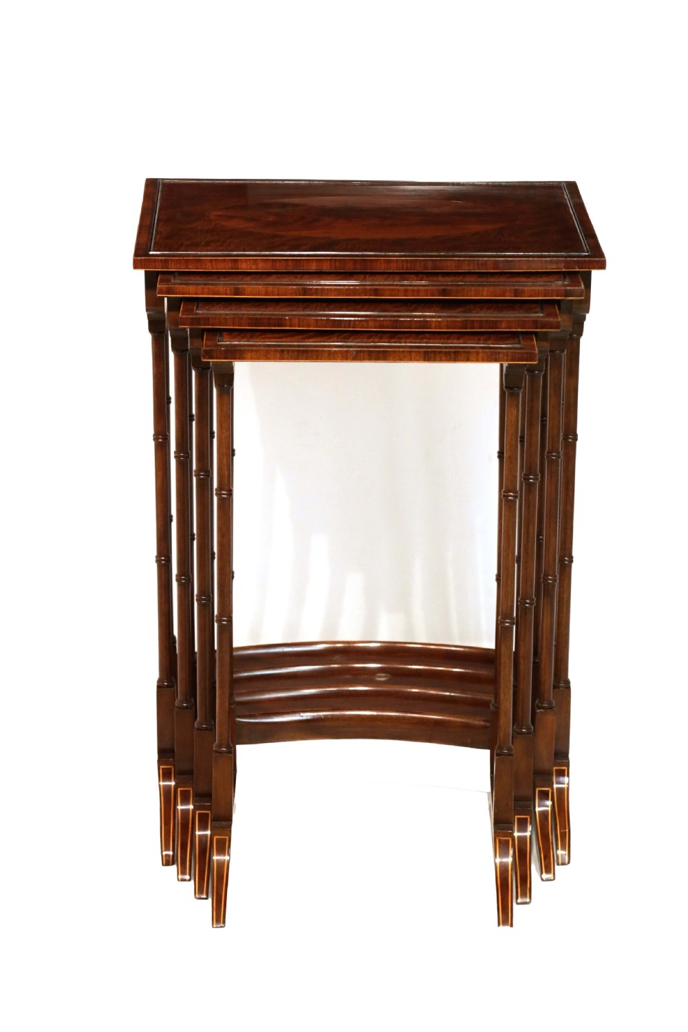 A set of four graduated nesting tables crafted from dark mahogany wood featuring line inlay and slender turned legs. View III