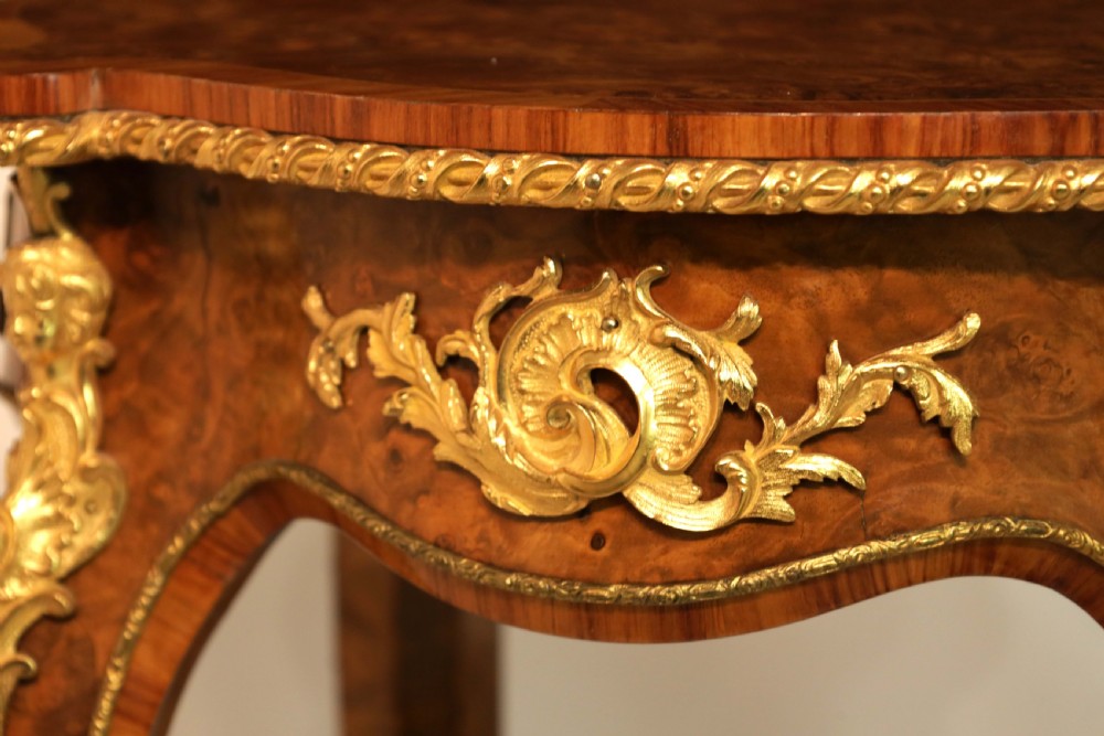 A Victorian burr walnut occasional table featuring a serpentine-edged top, cabriole legs, and ornate gilt bronze mounts along the apron and feet. View III