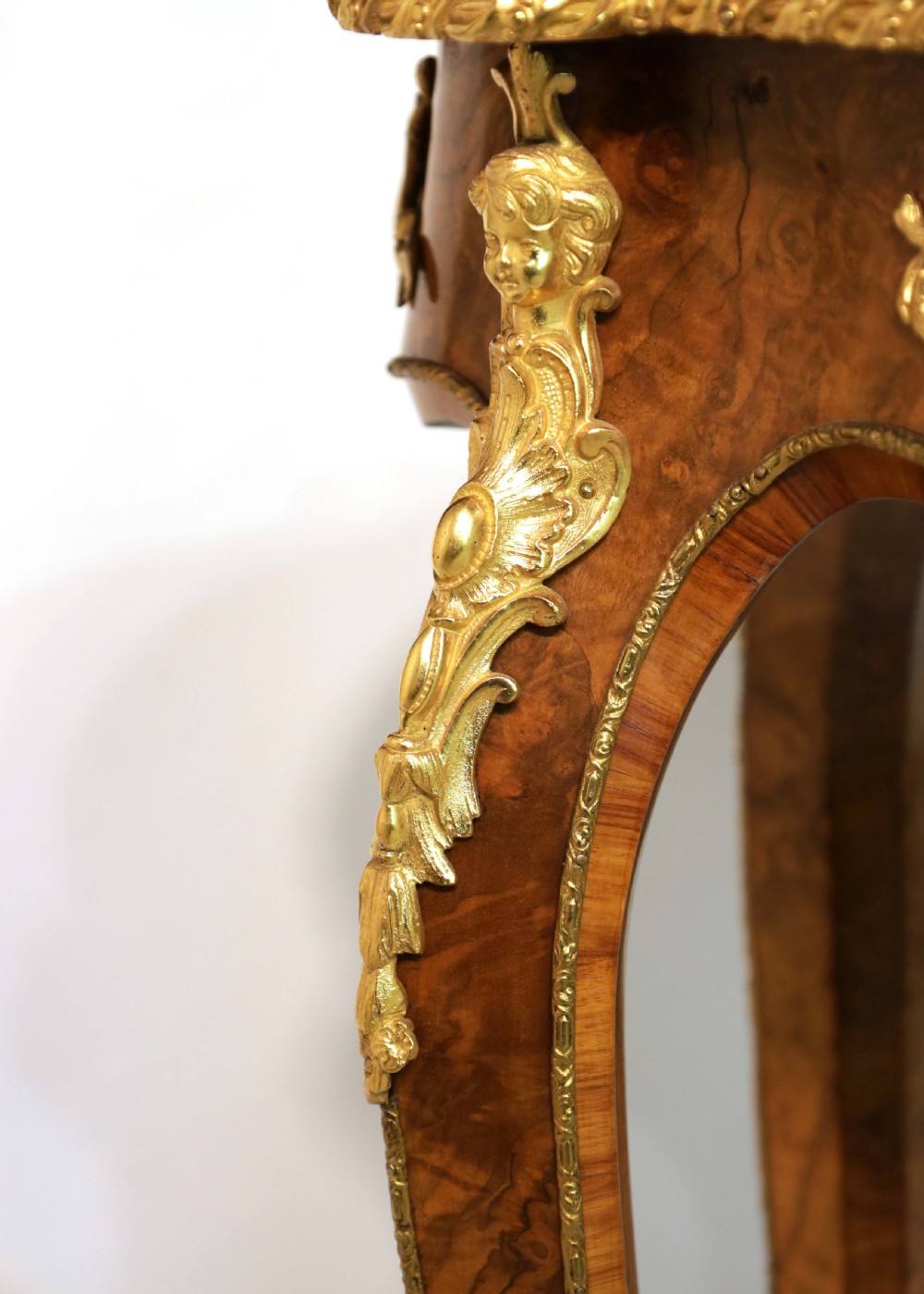 A Victorian burr walnut occasional table featuring a serpentine-edged top, cabriole legs, and ornate gilt bronze mounts along the apron and feet. View IV