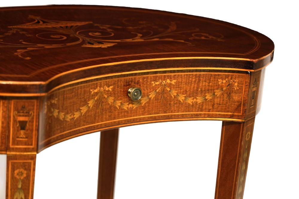 A late Victorian kidney-shaped mahogany side table featuring decorative floral marquetry inlay, slender tapered legs, a small apron drawer, and a lower tier shelf. View II